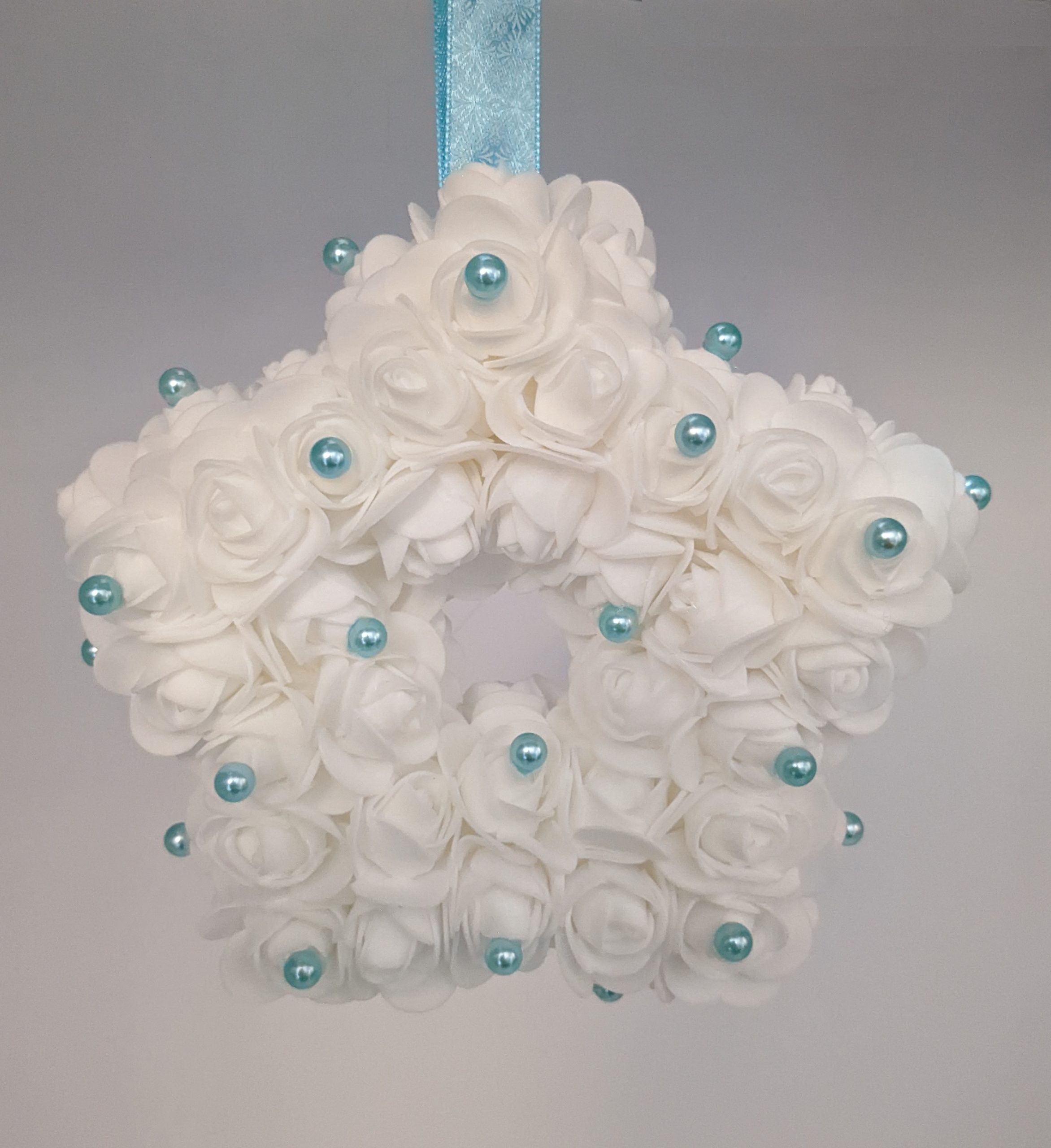 Etoile blanche avec ses perles couleur bleue