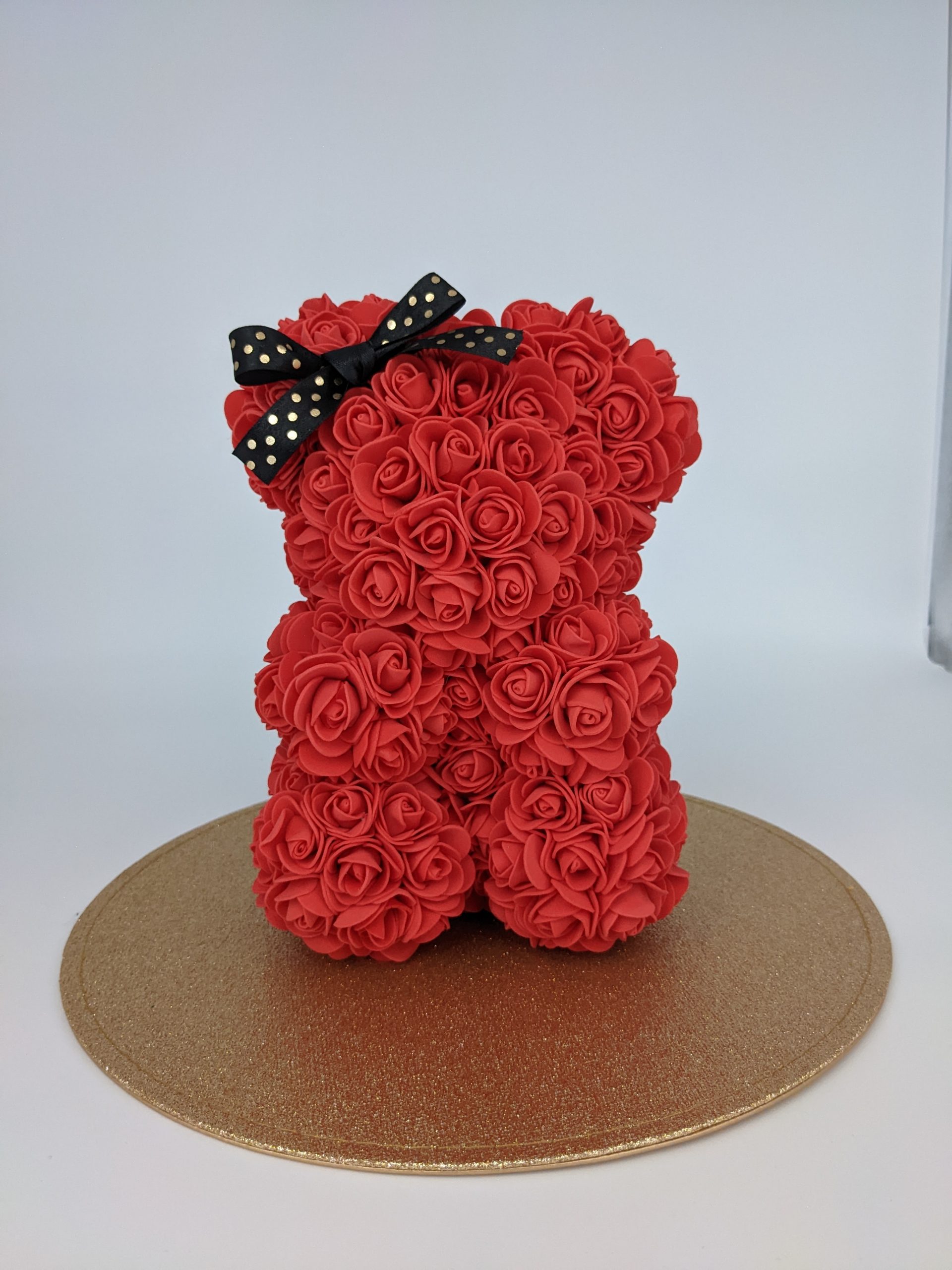 Ourson rouge avec son nœud noir à pois or